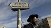 Ultraortodoxní Žid prochází kolem ukazatele k odvodové kanceláři