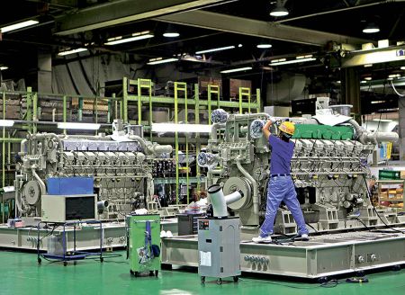 Workers are seen at the assembly line of the company's gas engine generator at Mitsubishi Heavy Industries Sagamihara plant in Sagamihara