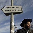 Ultraortodoxní Žid prochází kolem ukazatele k odvodové kanceláři