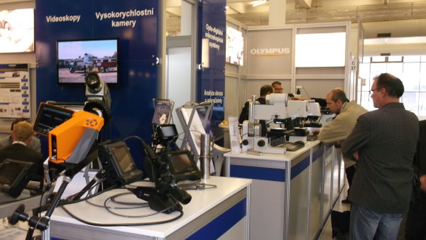Firma Olympus a její vysokorychlostní kamera (vpravo). Vzadu za ní mikroskopy, které mohou návštvníci sami vyzkoušet