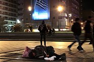 Spící bezdomovec na průduchu metra v centru Atén