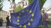 Muži drží vlajku EU na Staroměstském náměstí Protest proti EU v Praze