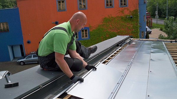 P�vodn� st�e�n� krytina tvo�en� tvarovan�m plechem byla demontov�na a nahrazena fotovoltaick�mi moduly s instalovan�m v�konem 20,16 kWp