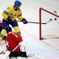 Henrik Sedin doklepává puk do švýcarské branky
