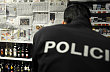 Policista si prohlíží provizorní zástěnu z novinového papíru na regálu s tvrdým alkoholem v jedné z prodejen v centru Prahy. Prohibice