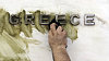 Údržbář čistí logo Řecké centrální banky v Aténách