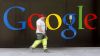Logo Google na zdi, kolem prochází muž Logo Google