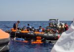 Záchranái zachraují imigranty z pevrácené rybáské lodi blízko libyjského pobeí.
