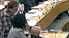 Útok na Ruperta Murdocha při výslechu - Murdochova manželka sedí za svým mužem v růžovém kostýmku Útok na Ruperta Murdocha při výslechu