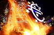 Ilustrační foto - Znak eura u sídla ECB ozářený ohněm při protestech ve Frankfurtu.