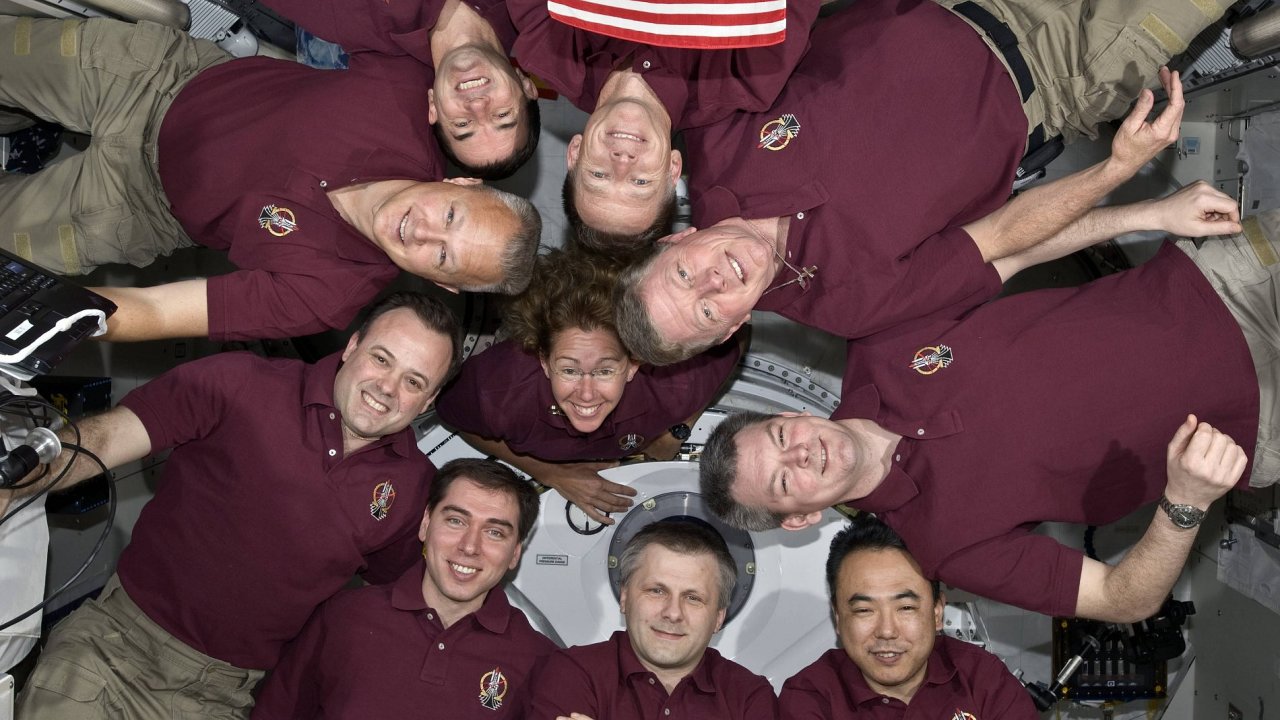 Astronauti na ISS s americkou vlajkou
