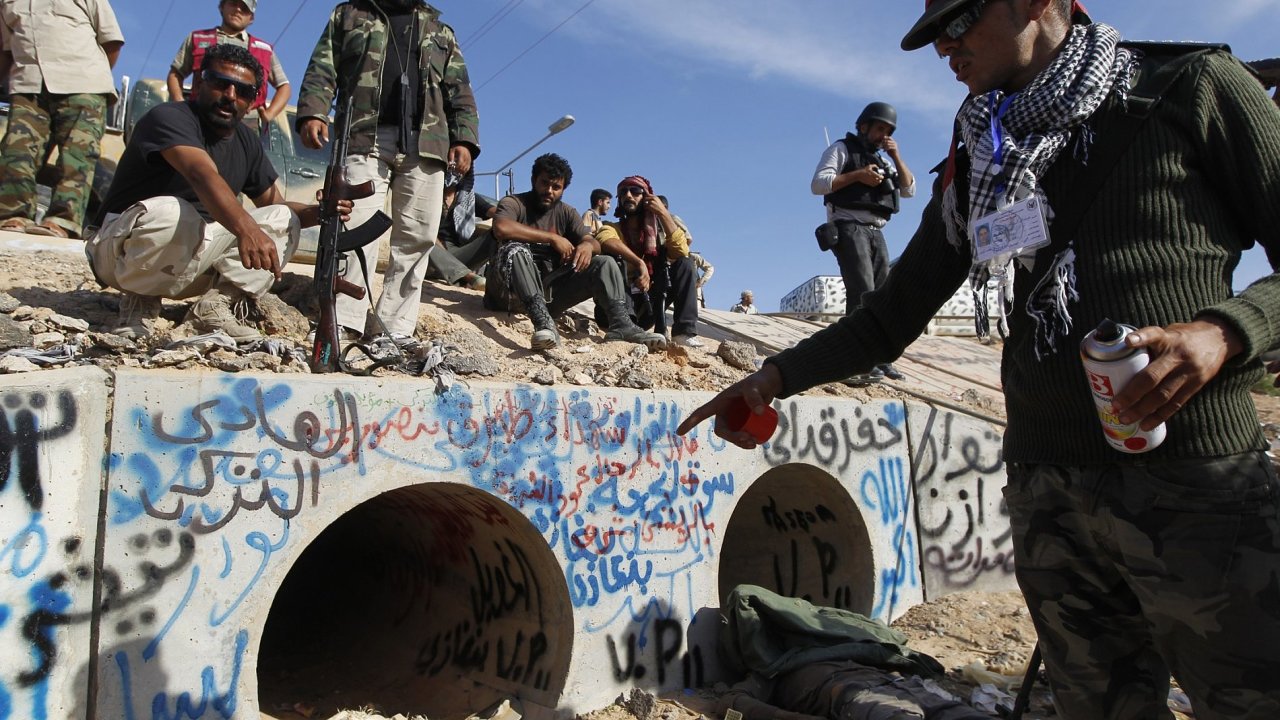 Povstalec ukazuje rouru, kde byl Kaddf zadren