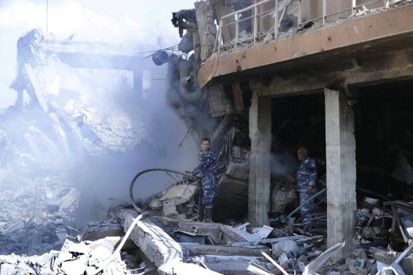 Fireman extinguish smoke that rises from the damage of the Syrian Scientific Research Center which was attacked by U.S.