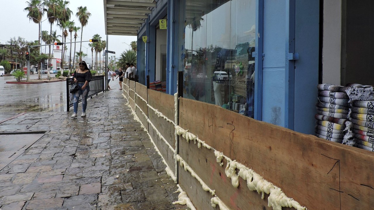 Majitel obchodu v Cabo San Lucas na mexickém poloostrovì Baja California se svùj majetek pøed blížícím se hurikánem Hilary snaží ochránit døevìným opevnìním.