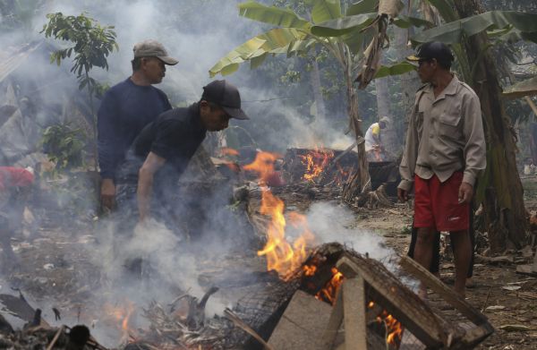 Lid&eacute; ukl&iacute;z&iacute; trosky po vln� tsunami v Indon&eacute;sii.