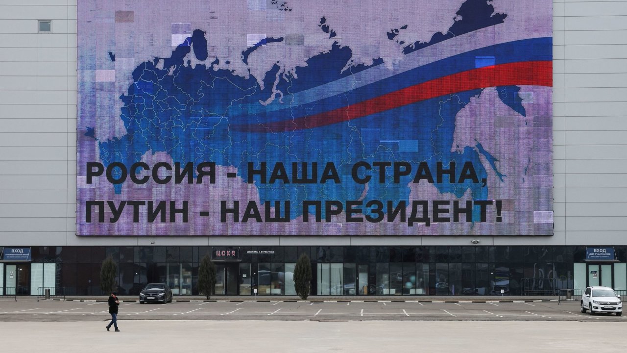 Člověk prochází v Moskvě kolem billboardu, na kterém je napsáno „Rusko – naše země, Putin – náš prezident“.