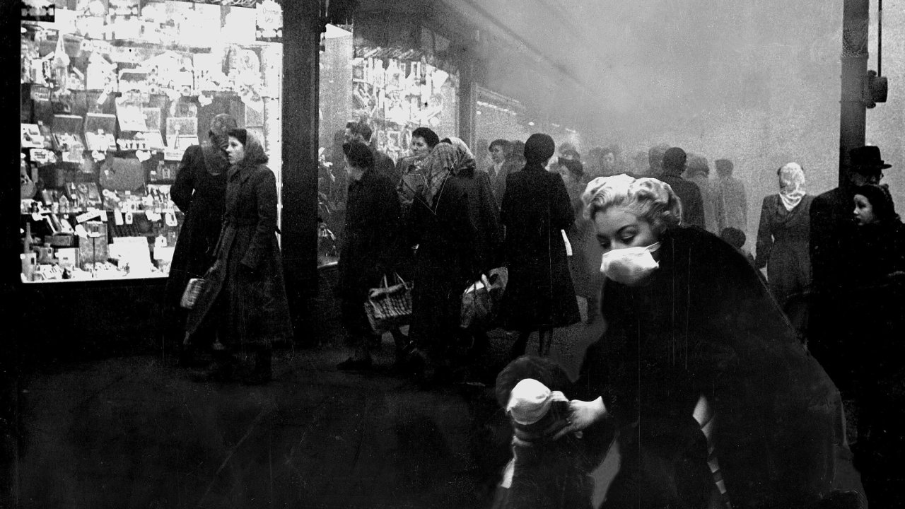 Sobotn odpoledne v Brixtonu. Na snmku ze 6. prosince roku 1952 se obyvatelka londnskho pedmst pokou ochrnit sebe i svho psa ped hustm smogem respirtorem.