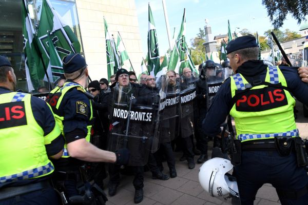 Police officers stand next to counter-demonstrators prior to the Nordic Resistance Movement's (NMR) march in central Gothenburg, Sweden September 30, 2017.
