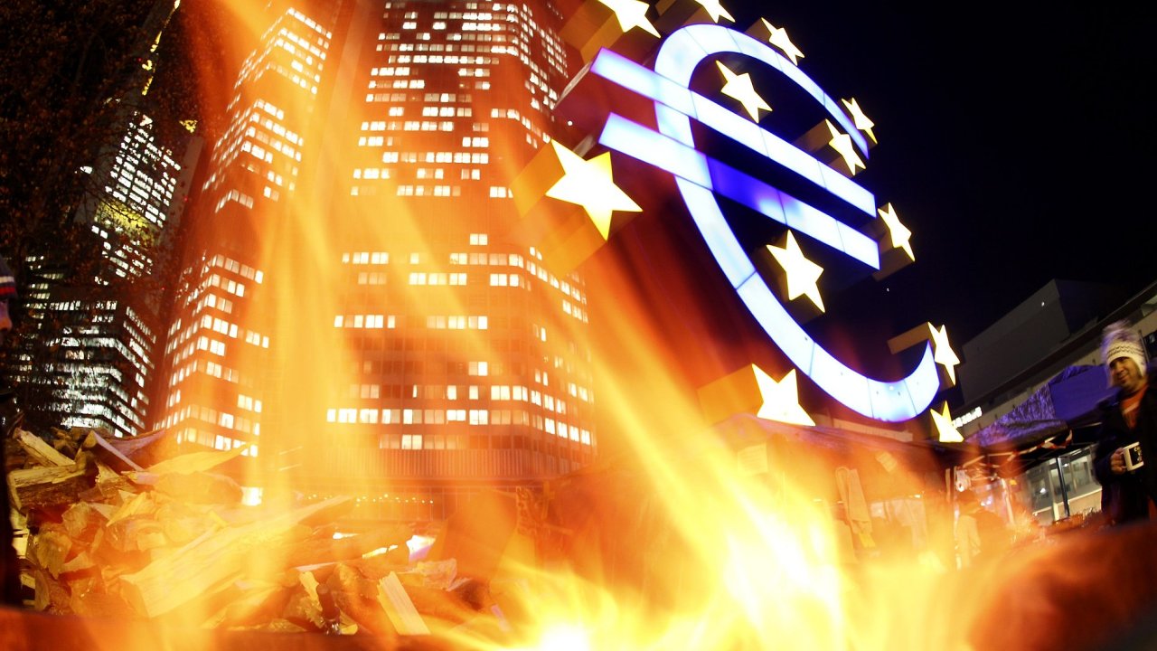 Znak eura u sídla ECB ozáøený ohnìm pøi protestech ve Frankfurtu