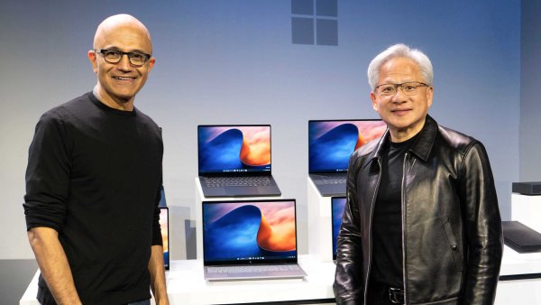 Šéfové Microsoftu a Nvidie Satya Nadella a Jensen Huang s počítači Surface...