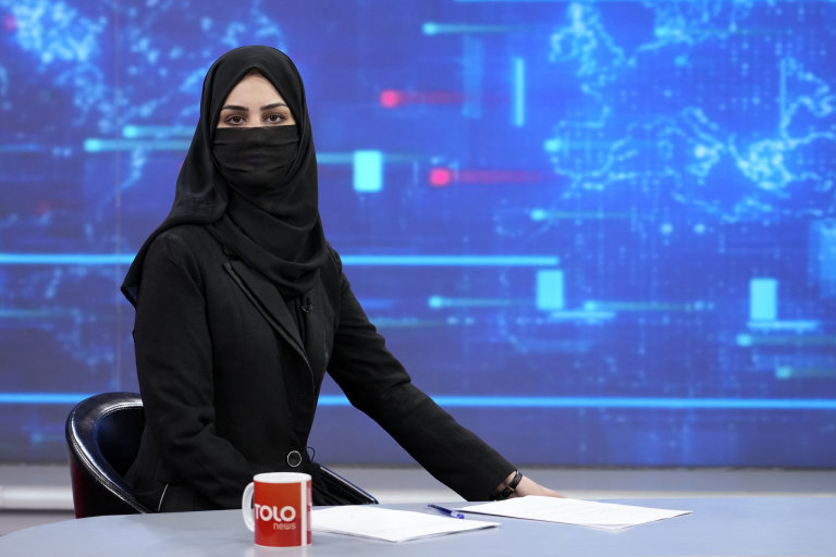 TV anchor Khatereh Ahmadi wears a face covering as she reads the news on TOLO NEWS