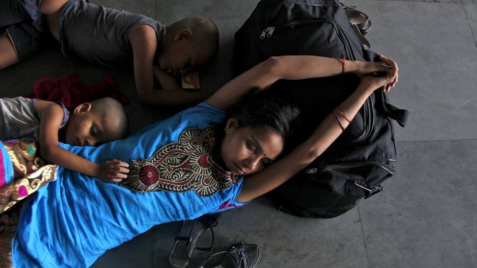 Lidé v indickém Allahabadu spí pøi èekání na vlak. Teploty by bìhem dne mìly pøekroèit 46 stupòù Celsia.