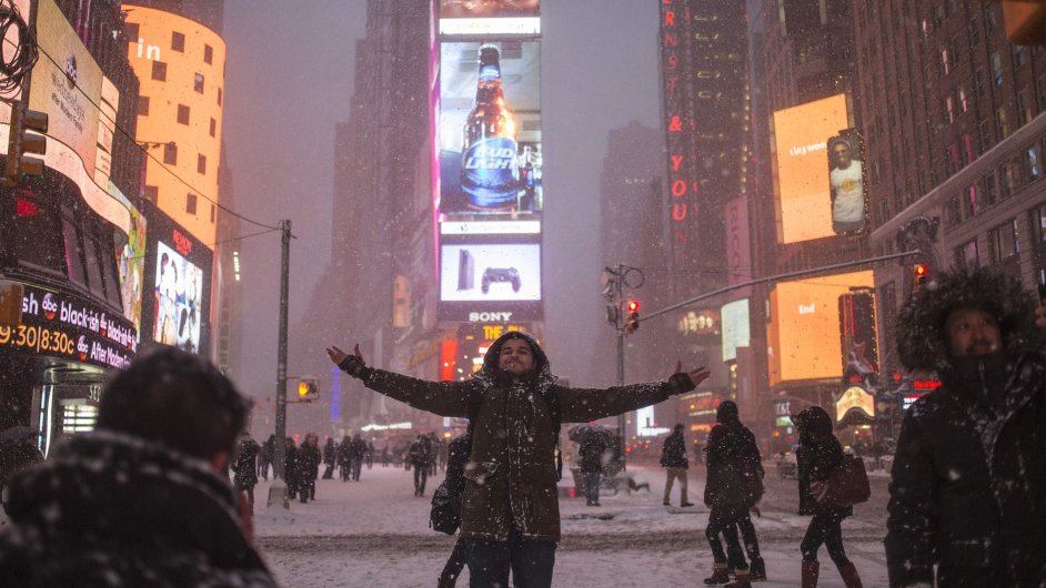 Turista vt padajc snh na nmst Times Square v americkm New Yorku.