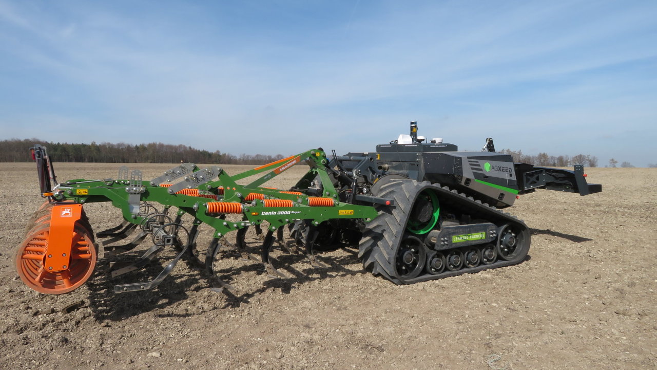 Autonomn� p�sov� nosi� n��ad� � robotick� traktor AgXeed AgBot, kter� nese radli�kov� hloubkov� kyp�i� ke zpracov�n� p�dy Amazone Cenius 3000 Super = zpracov�n� p�dy bez obsluhy.