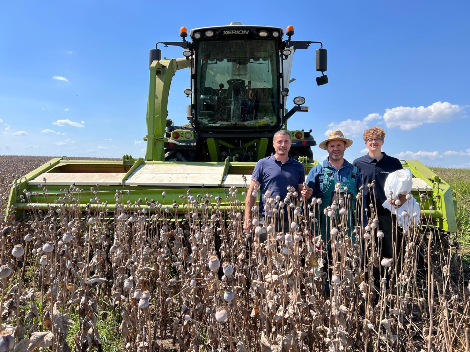 U kombajnu se skliz�ov�m adapt�rem upraven�m pro sklize� cel�ch makovic stoj� Milan Kroul�k za �ZU a Ji�� �tvrte�ka se synem z farmy LABRIS s.r.o.