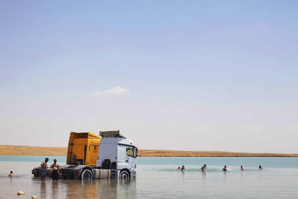 Arabští a kurdští civilisté plavou v mosulské přehradní nádrži, Mosul, Irák, 25. 6. 2015.