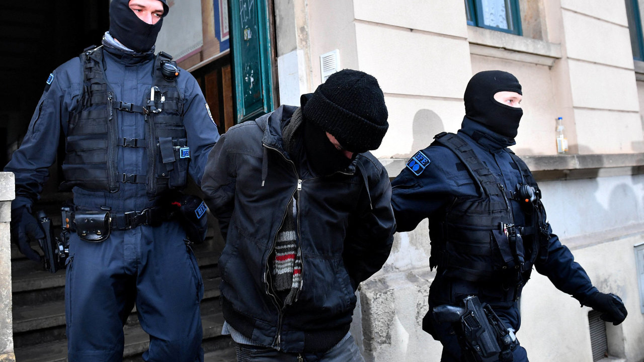 Police detain a suspect during raids in several locations in Dresden