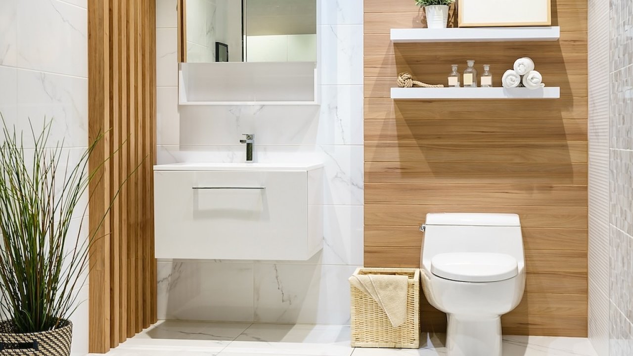 Modern spacious bathroom with bright tiles with toilet and sink. Side view