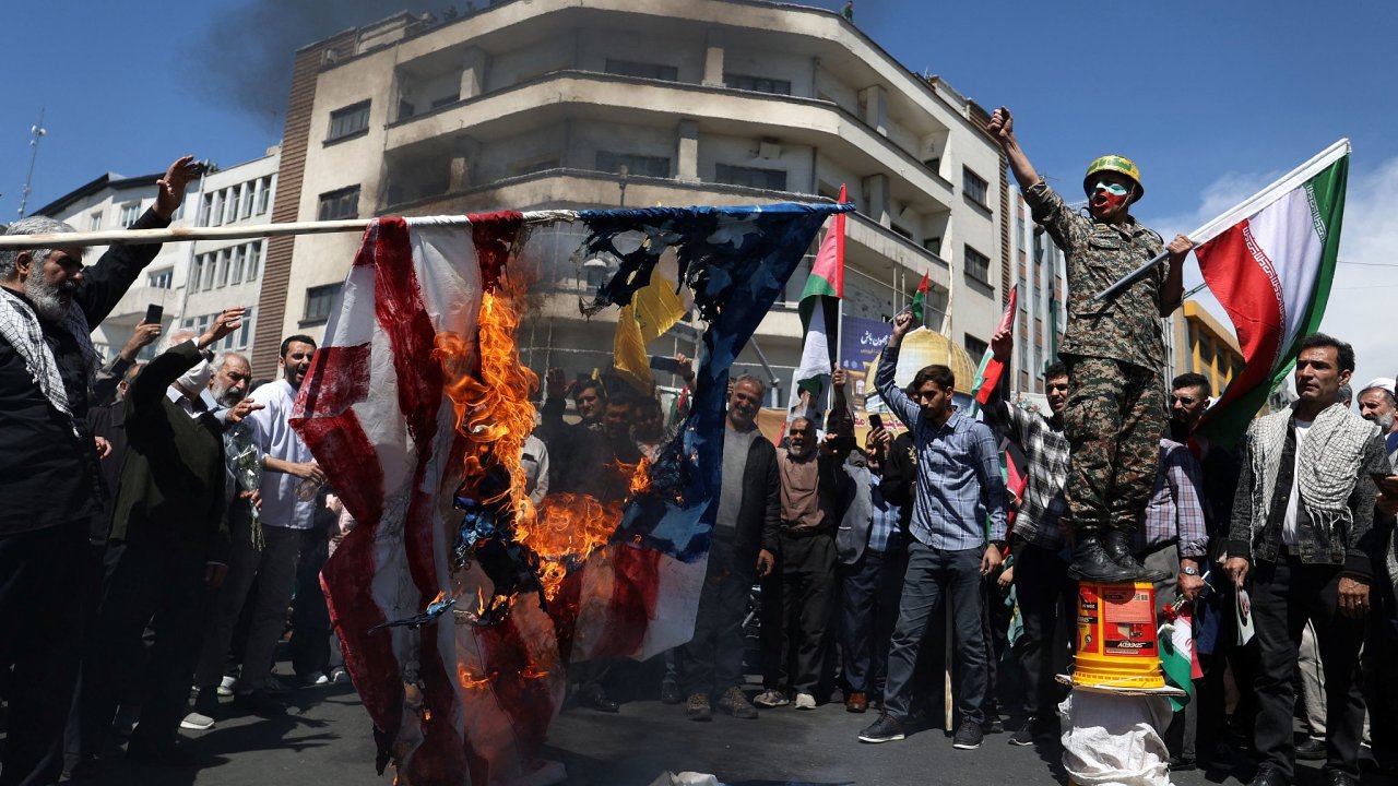 rnci pl americkou vlajku bhem shromdn 5. dubna u pleitosti pohbu len islmskch revolunch gard, kte byli zabiti pi dajnm izraelskm nletu na rnsk velvyslanectv v Damaku