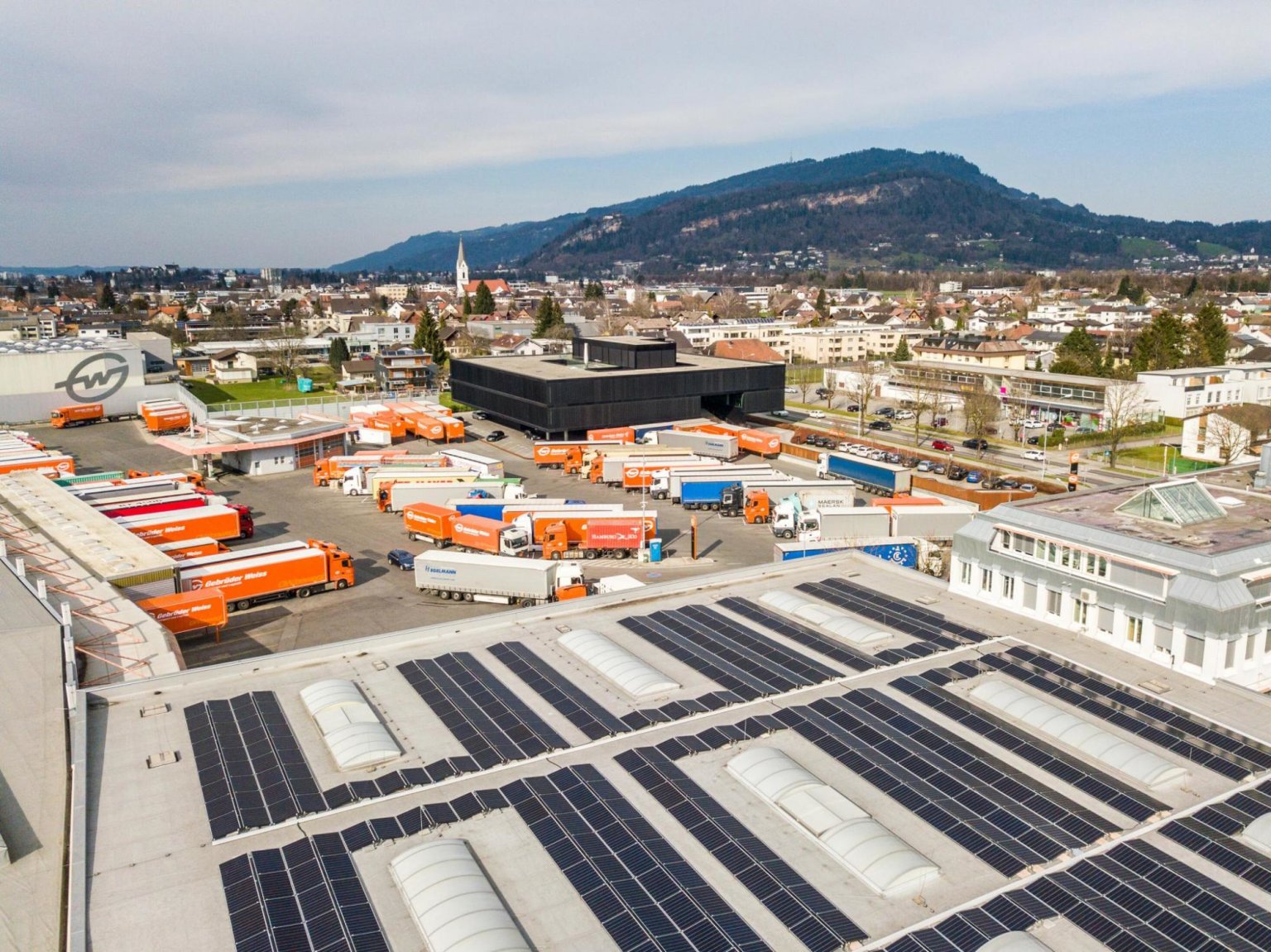 Do roku 2030 chce spoleènost Gebrüder Weiss dosáhnout na všech svých poboèkách uhlíkové neutrality. Na snímku fotovoltaická elektrárna v lokalitì Lauterach, v pozadí centrála firmy.