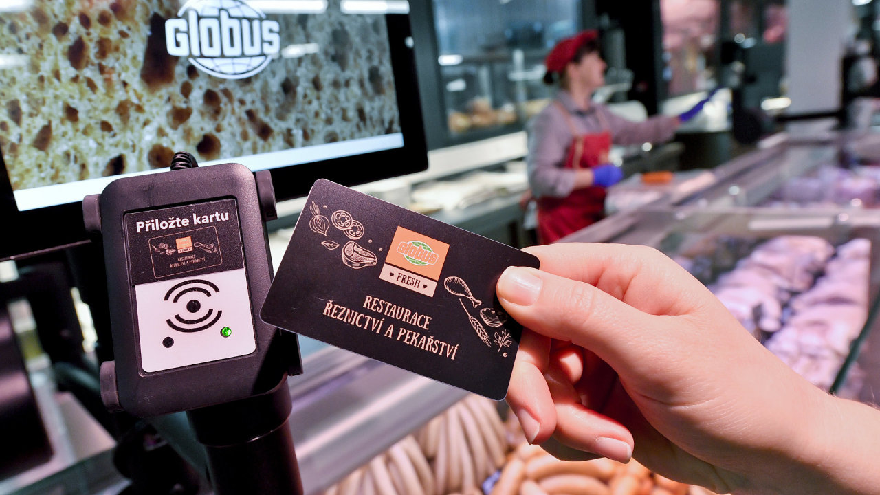 Zákaznice zaznamenává transakci do nového platebního systému v prodejnì Globus Fresh.