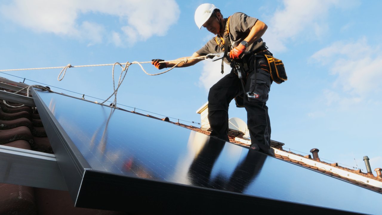 Mont fotovoltaickho panelu pracovnkem spolenosti Malina.