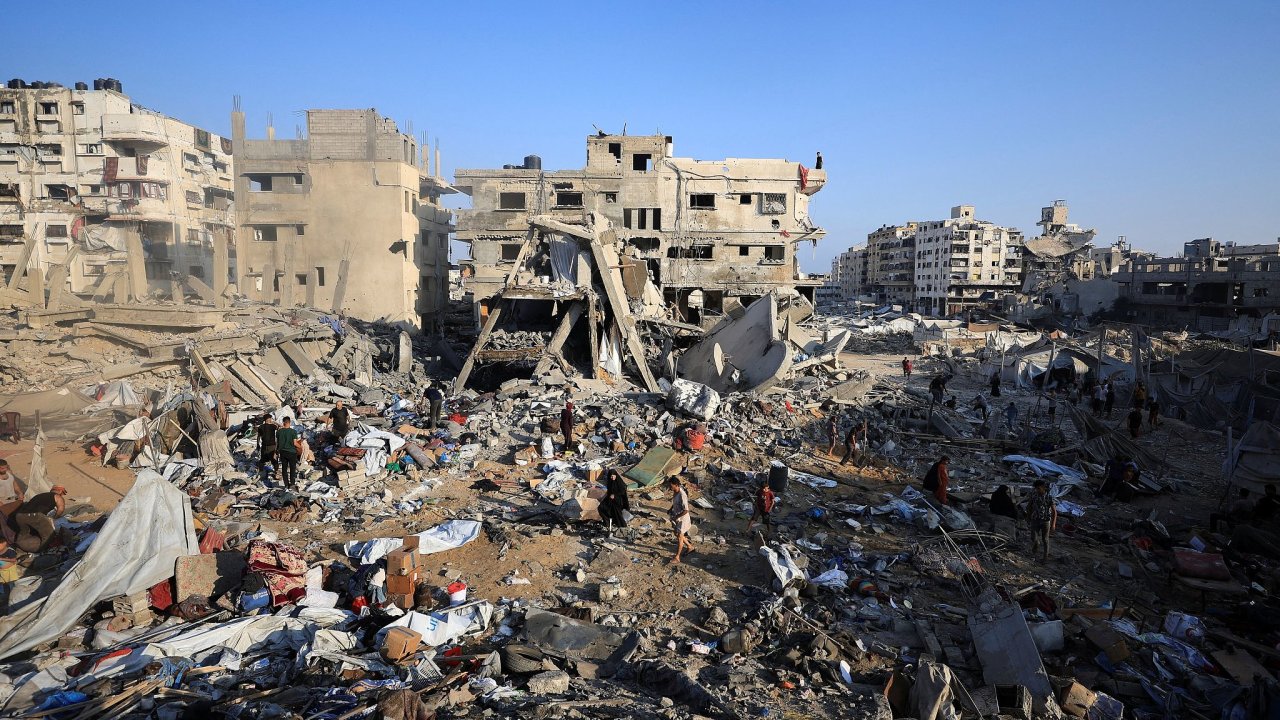 Palestinians inspect the site of Wednesday’s Israeli strike on a house whose...
