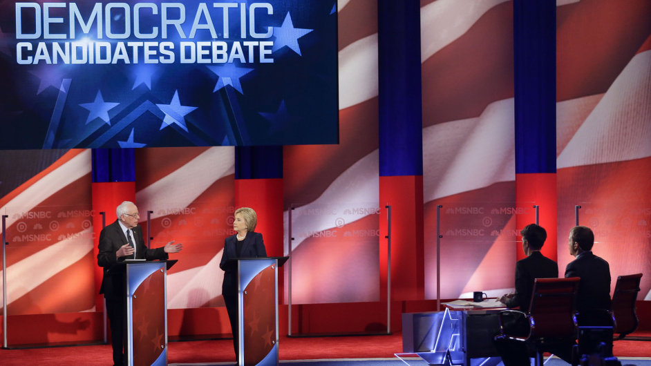 Debate moderators Rachel Maddow and Chuck Todd listen as Democratic presidential candidates