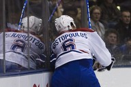 Hokejista Montrealu Tom Kostopoulos tvrd nar na mantinel Mika van Ryna z Toronta. 