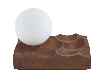 Poetická lampa od designéra Gregora Korolewicze připomíná měsíc visící nad suchou, větrem bičovanou krajinou, jako je poušť Atacama v Chile. Foukaná skleněná koule sedí na masivní ořechové základně.