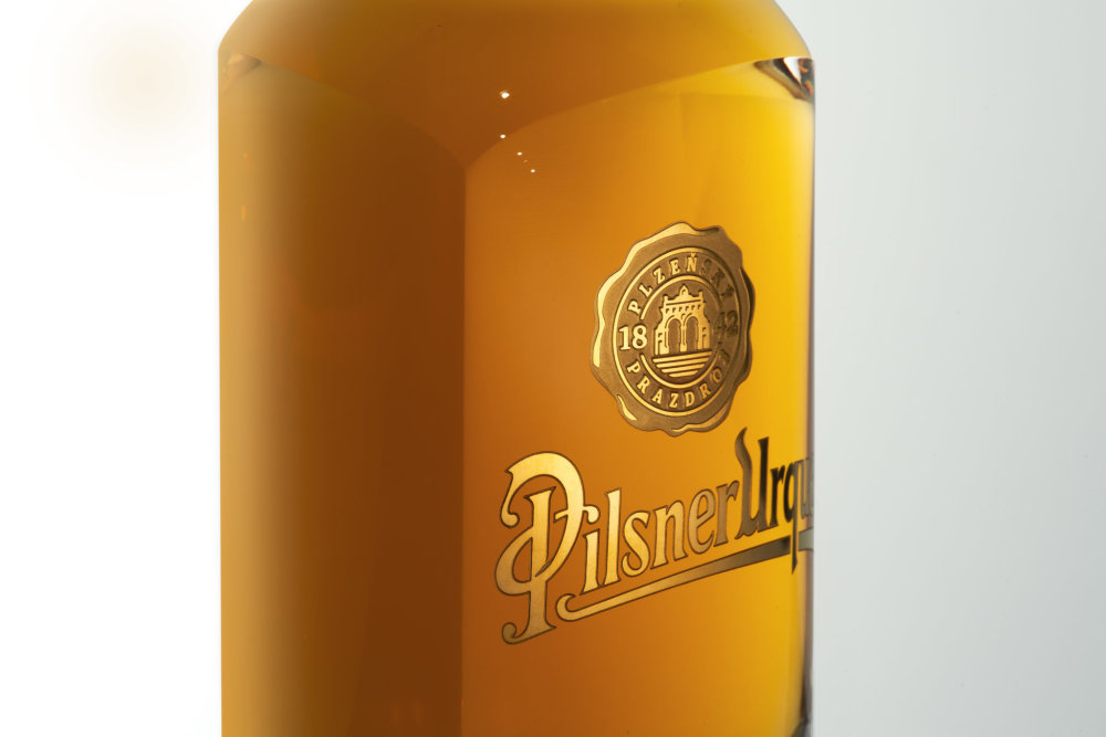 Pivní lahev Pilsner Urquell od designéra Michala Froňka, sklárny Moser a manufaktury Bohematic