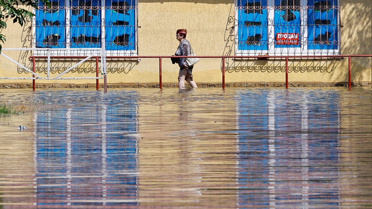 Mìsto Nova Kachovka se ponoøilo do vody. Místní obyvatelka na fotografii kráèí po zatopené ulici po zøícení Kachovské pøehrady.