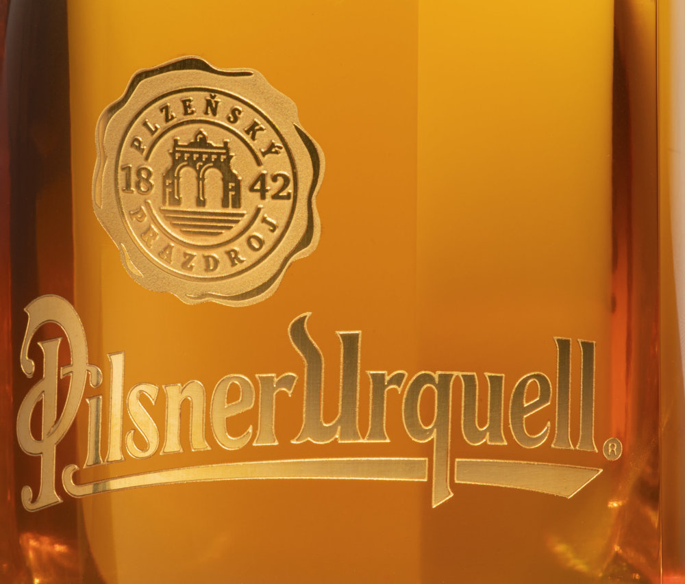 Pivní lahev Pilsner Urquell od designéra Michala Froňka, sklárny Moser a manufaktury Bohematic