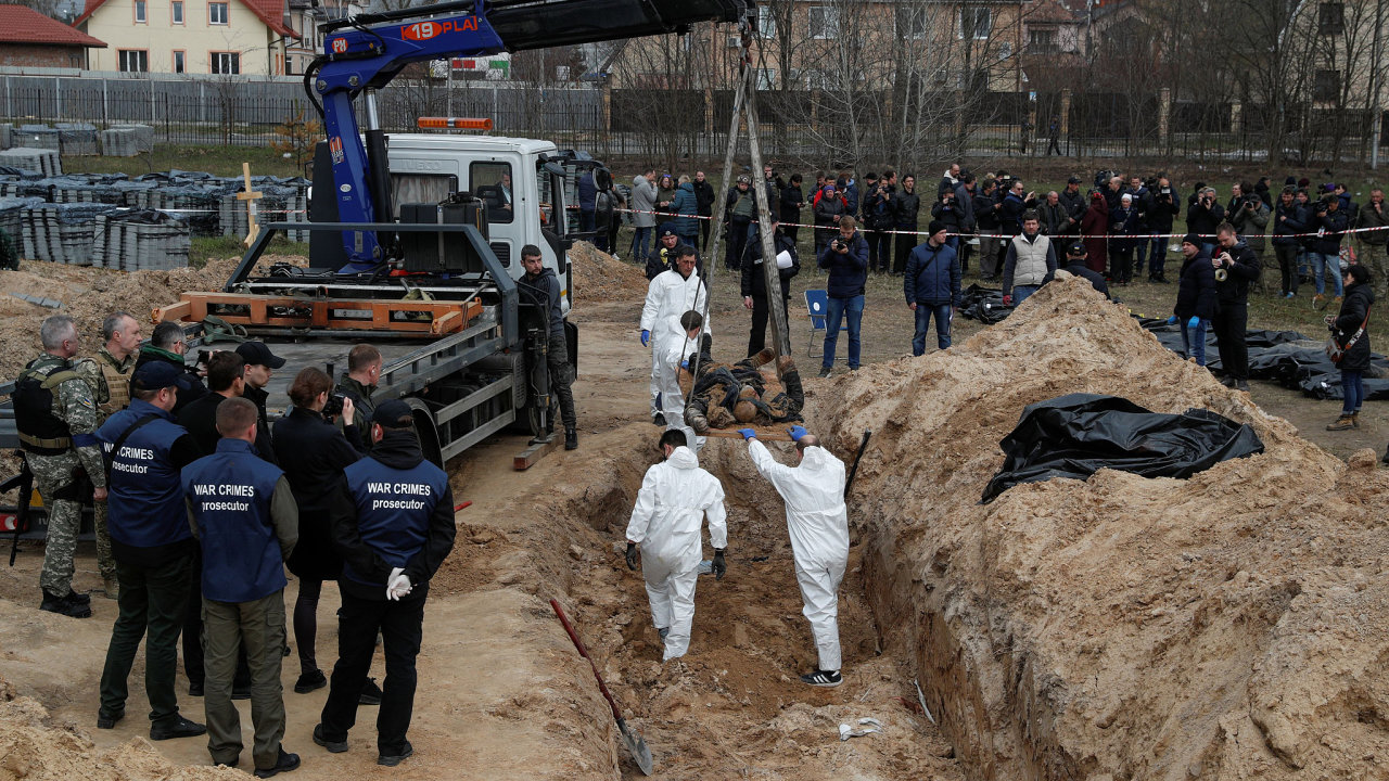 Forenzní technici exhumují těla civilistů, kteří byli podle ukrajinských představitelů zabiti během ruské invaze a poté pohřbeni v hromadném hrobě ve městě Buča u Kyjeva na Ukrajině.