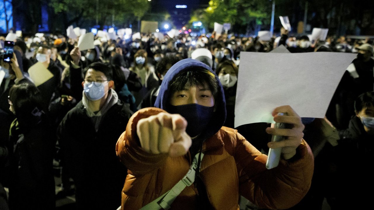 Lidé v Pekingu drží prázdné papíry na znamení protestu proti pøísným covidovým opatøením.