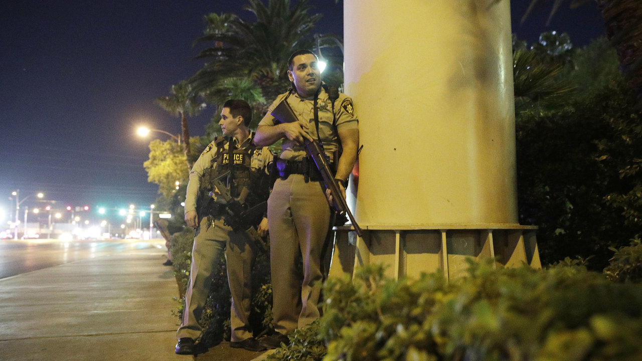 Police officers take cover near the scene of a shooting near the Mandalay Bay resort and casino on the Las Vegas Strip, policie usa stelec