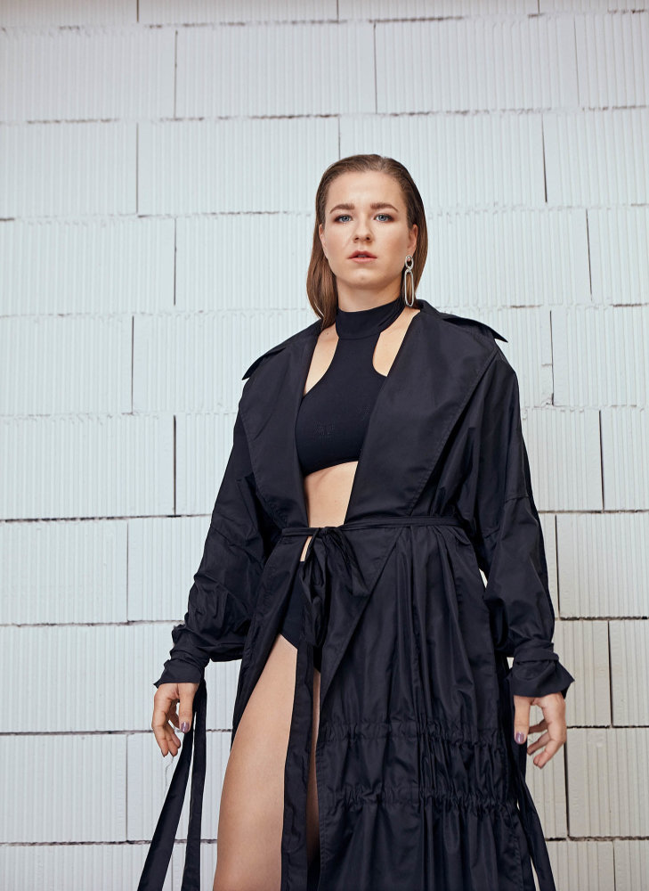 Stříbrná náušnice Alta Ora, černý plášť Zoltán Tóth, obojí prodává Red Salon, dvoudílné plavky Hermès.