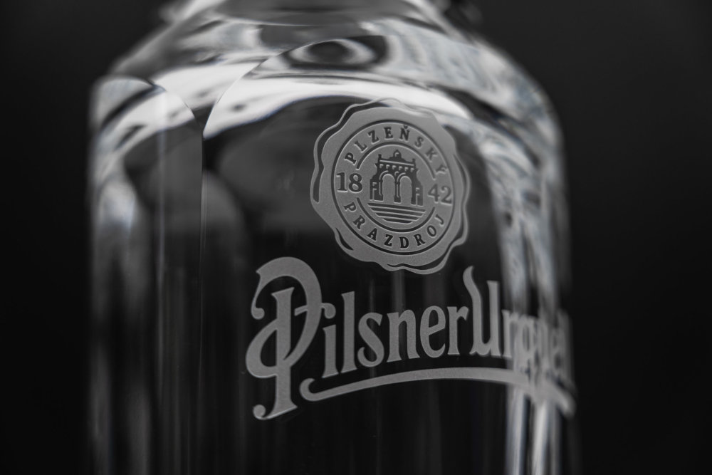 Pivní lahev Pilsner Urquell od designéra Michala Froňka, sklárny Moser a manufaktury Bohematic