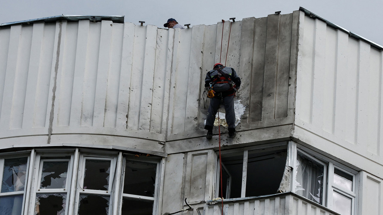 Dìlníci opravují škody na støeše vícepodlažního bytového domu po nahlášeném útoku dronu v Moskvì