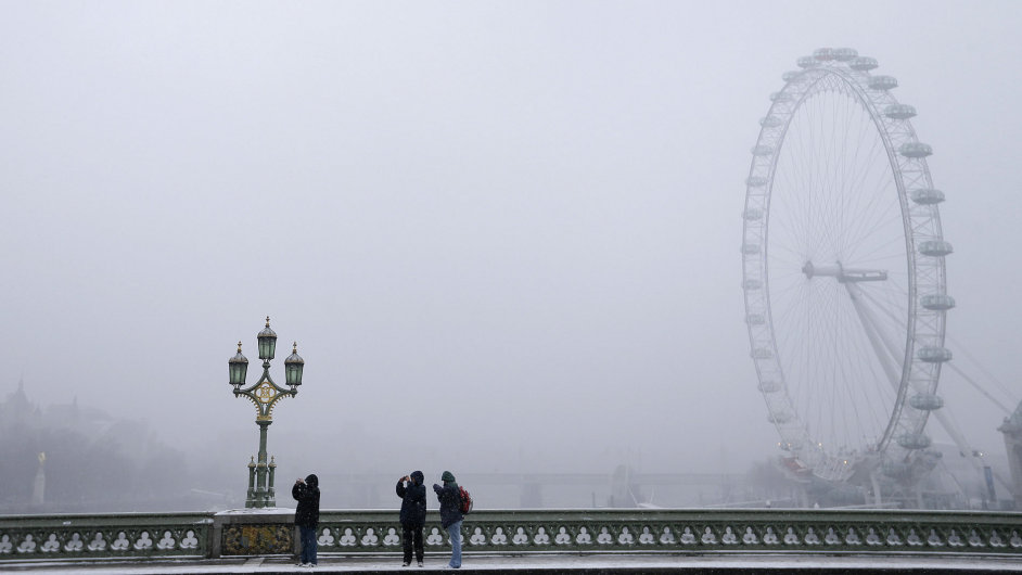 Snilo i v Londn. Turist si ve vnici fot londnsk pamtky.